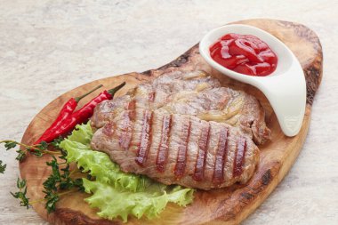 Ketçaplı ızgara domuz budu bifteği.