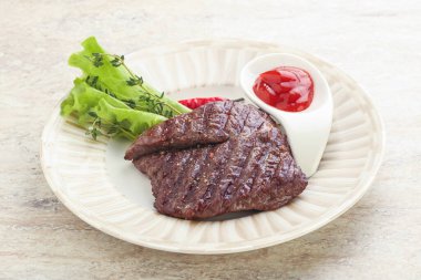 Izgara pala etekli biftek kekik ve ketçap servis edilir.