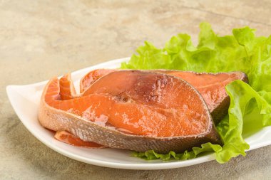 İki pembe somon balığı bifteği. Salata yaprağı.