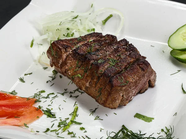 牛のステーキのグリルは玉ねぎとハーブを提供 — ストック写真