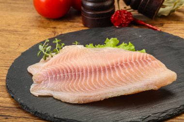 Pişirmek için çiğ tilapia balığı filetosu.