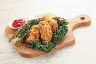 Kızarmış tavuk kanadı ve ketçap.