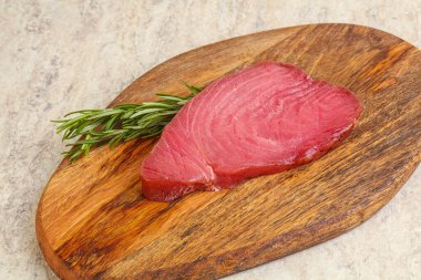 Teknede pişirmek için çiğ ton balığı bifteği. Biberiye servis ediliyor.