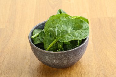 Tahta arka planda taze yeşil ıspanak yaprakları var.