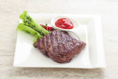 Izgara pala etekli biftek kekik ve ketçap servis edilir.