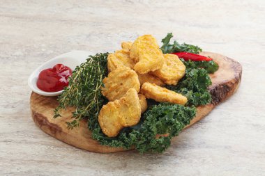 Kızarmış tavuk nugget ve domates ketçapı.