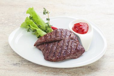 Izgara pala etekli biftek kekik ve ketçap servis edilir.