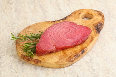 Teknede pişirmek için çiğ ton balığı bifteği. Biberiye servis ediliyor.