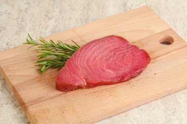 Teknede pişirmek için çiğ ton balığı bifteği. Biberiye servis ediliyor.