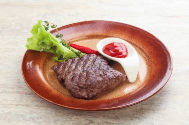 Izgara pala etekli biftek kekik ve ketçap servis edilir.