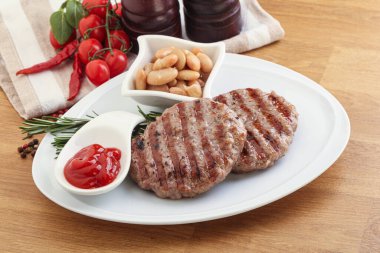 Sos ve fasulyeli ızgara biftek burger pirzolası.