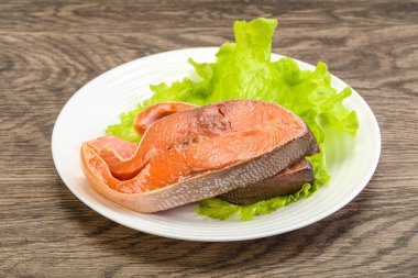 İki pembe somon balığı bifteği. Salata yaprağı.