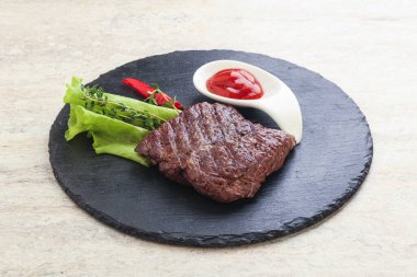 Izgara pala etekli biftek kekik ve ketçap servis edilir.