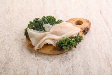 Ahşap tahtada pişirmek için çiğ mürekkep balığı