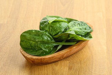 Tahta arka planda taze yeşil ıspanak yaprakları var.