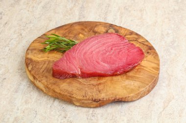 Teknede pişirmek için çiğ ton balığı bifteği. Biberiye servis ediliyor.