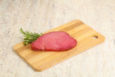 Teknede pişirmek için çiğ ton balığı bifteği. Biberiye servis ediliyor.