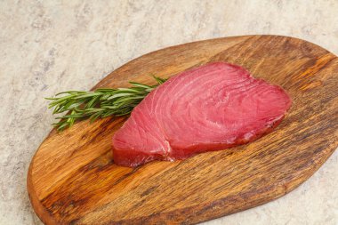 Teknede pişirmek için çiğ ton balığı bifteği. Biberiye servis ediliyor.