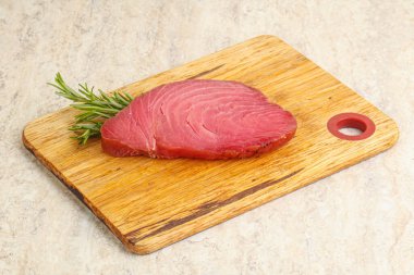 Teknede pişirmek için çiğ ton balığı bifteği. Biberiye servis ediliyor.