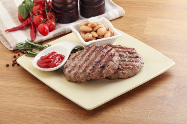 Sos ve fasulyeli ızgara biftek burger pirzolası.