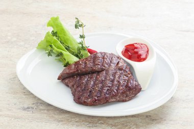 Izgara pala etekli biftek kekik ve ketçap servis edilir.