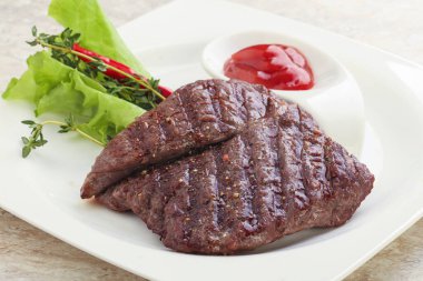 Izgara pala etekli biftek kekik ve ketçap servis edilir.