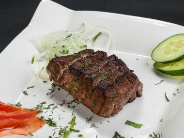 Izgara biftek, soğan ve ot.
