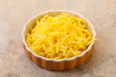 Yemek pişirmek için kasede dilimlenmiş sarı peynir.