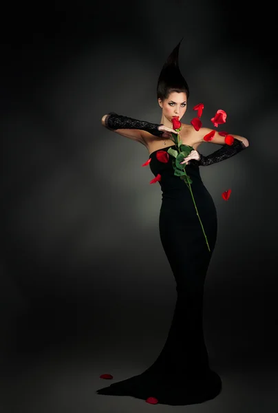 Mysterious woman in dark hood with rose — Stock Photo, Image