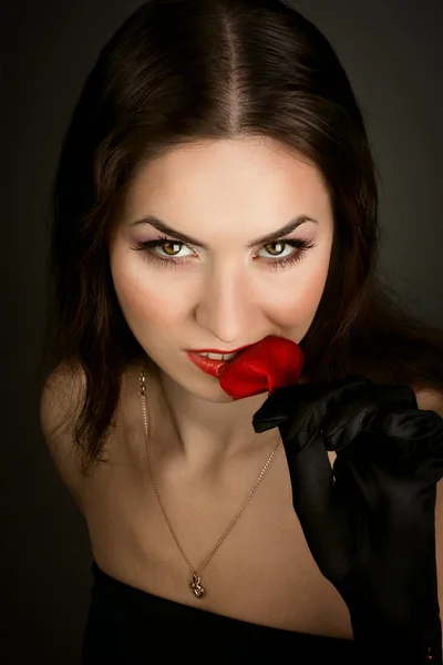 Mysterious woman in dark hood with rose leaf — Stock Photo, Image