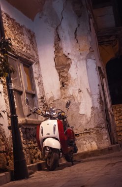 Beyaz vintage scooter geceleri park etmiş.