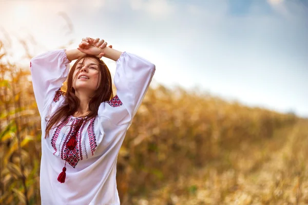 Woman in traditional shirt standing on cornfield — Stock Photo, Image