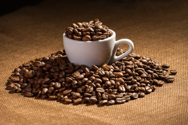 Copo cheio de grãos de café preto — Fotografia de Stock