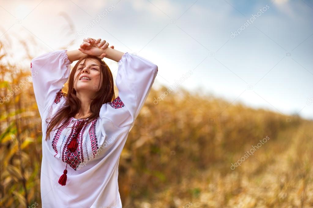 Woman in traditional shirt standing on cornfield