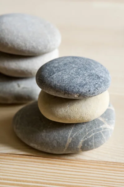Six spa zen stones stacked on a wood background