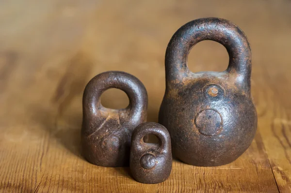 Drie kleine kalibratie gewichten op houten achtergrond — Stockfoto