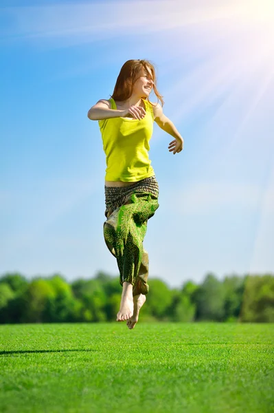 Giovane donna che corre su un prato verde — Foto Stock