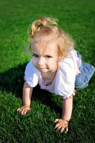 Menina do bebê rastejando na grama verde no parque — Fotografia de Stock