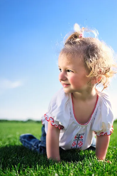 Schattig klein meisje, kruipen op het groene gras in het park — Stockfoto