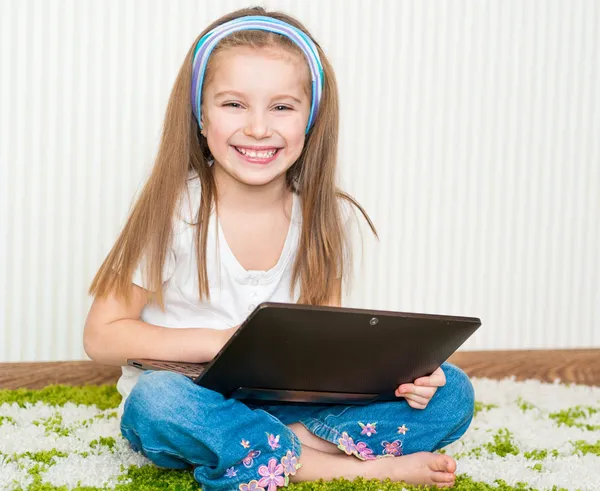 Petite fille avec un ordinateur portable — Photo