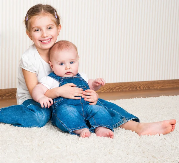 Two sisters sitting on the floor Royalty Free Stock Images