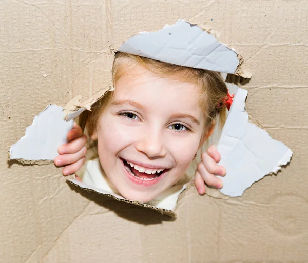 Niño en agujero de papel roto — Foto de Stock