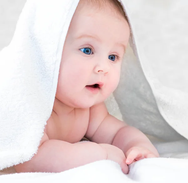 Bebê sob o cobertor branco — Fotografia de Stock