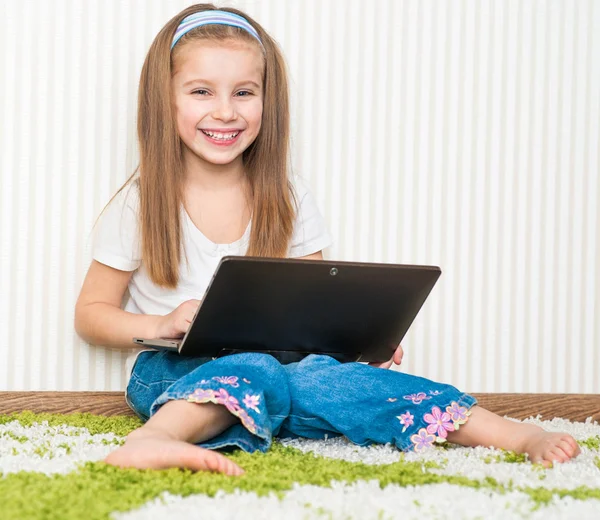 Little girl with a laptop — Stock Photo, Image