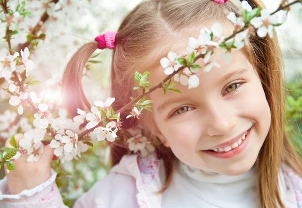 Little girl with bush blossoming — Stock Photo, Image