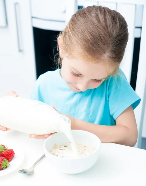 Beetje meisje gieten melk — Stockfoto