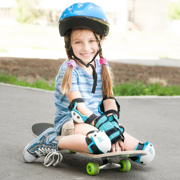 Petite fille assise sur un skateboard — Photo