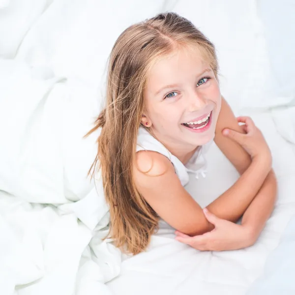 Altı yaşındaki kız beyaz yatakta Stok Fotoğraf