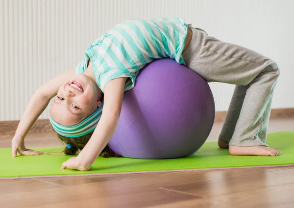 Holčička dělá gymnastické cvičení — Stockfoto