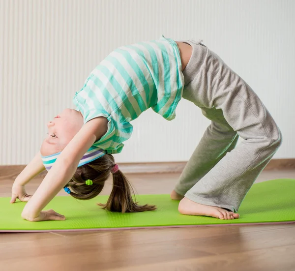 Mały dziewczyna robi ćwiczenia gimnastyczne — Zdjęcie stockowe